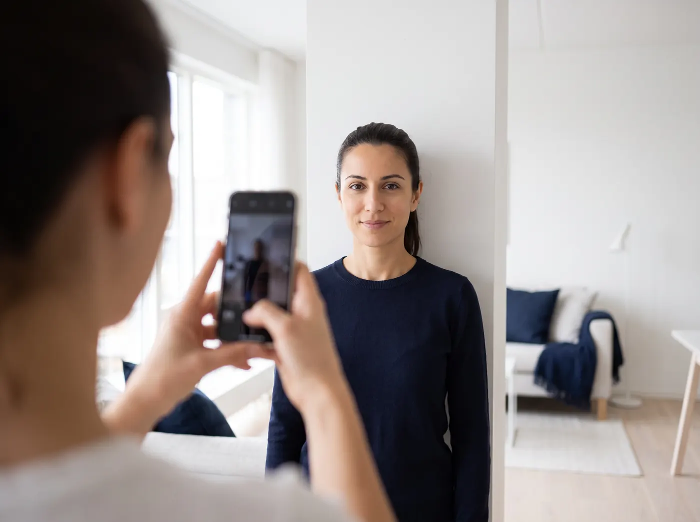 A friend takes a photo against a plain wall at home
